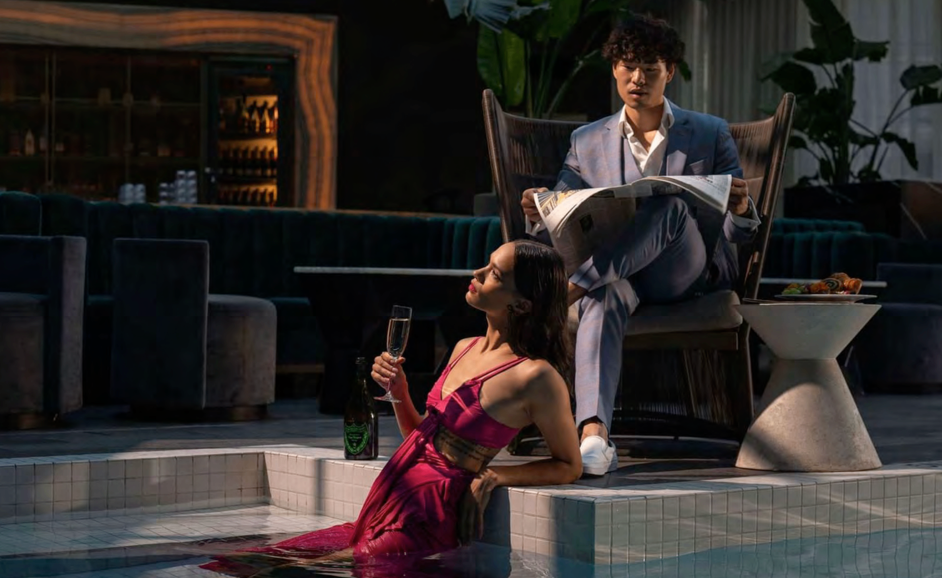 Paradox editorial poolside scene with a couple in formalwear at night.